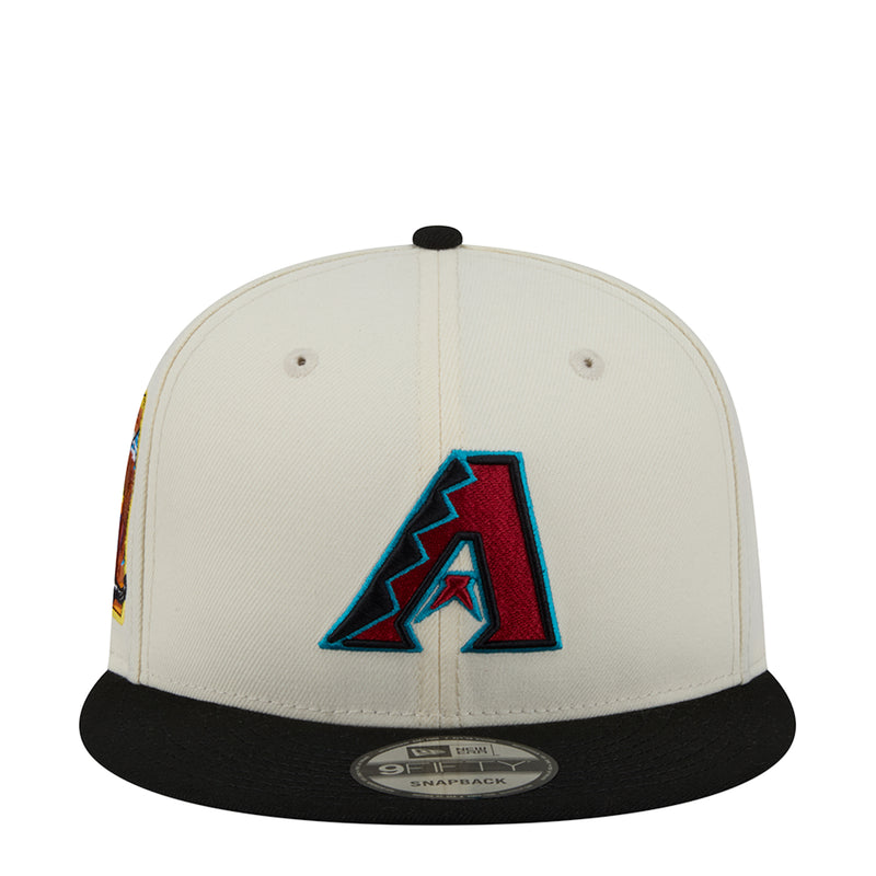 Two-tone baseball cap with white crown, black brim, and blue A logo front
