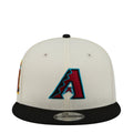 Two-tone baseball cap with white crown, black brim, and blue A logo front