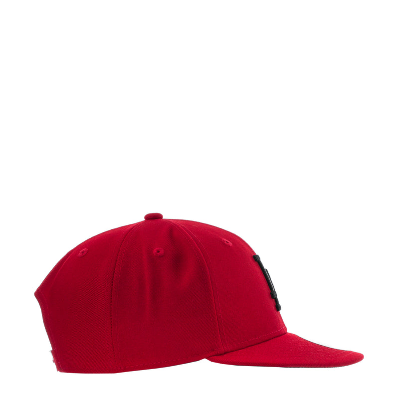Red baseball cap side view with small black embroidered detail