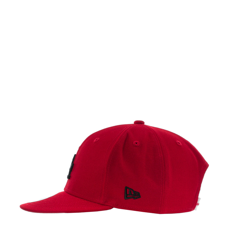 Red baseball cap back view with small black embroidered LA icon