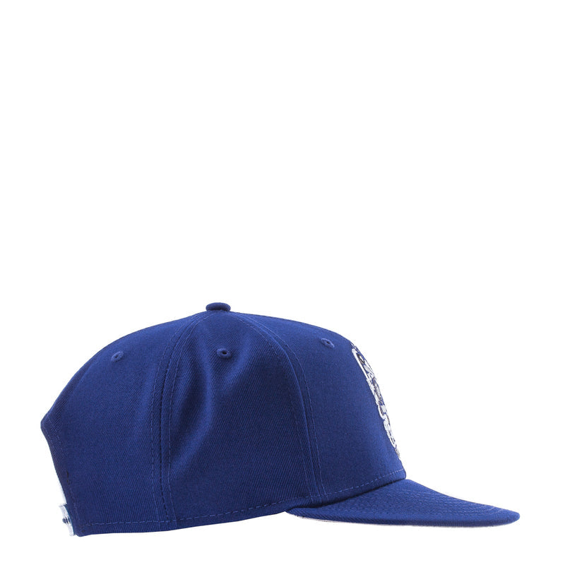 Royal blue baseball cap side view with white embroidered skull artwork