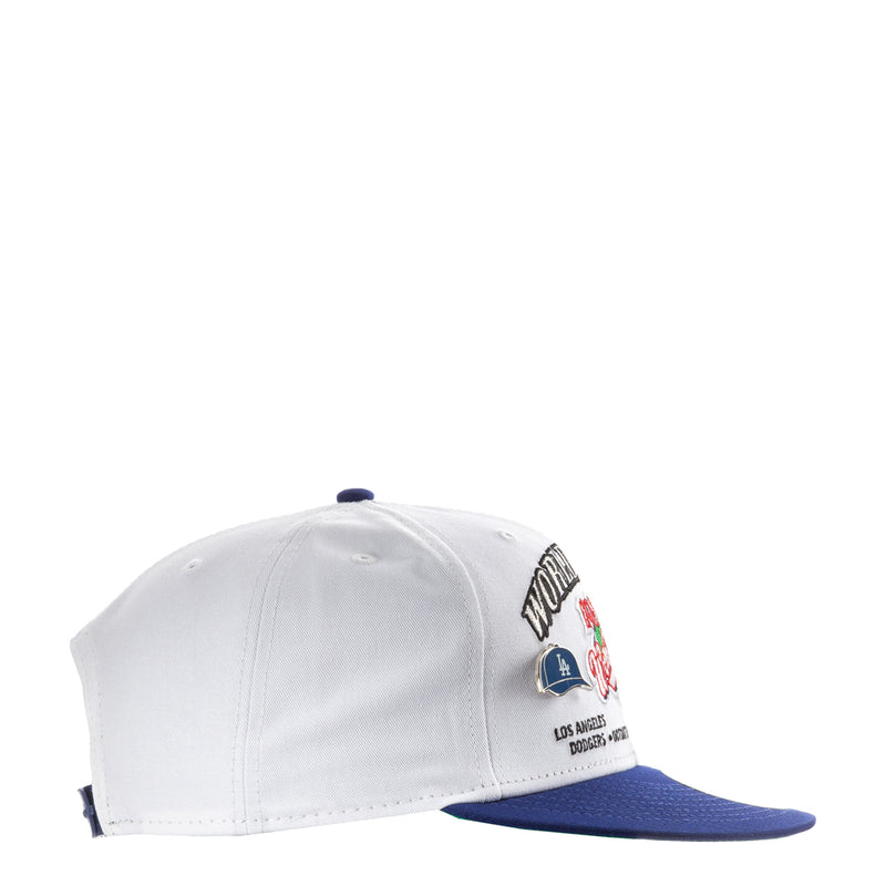 White baseball cap with blue brim and small team logo patch on the side