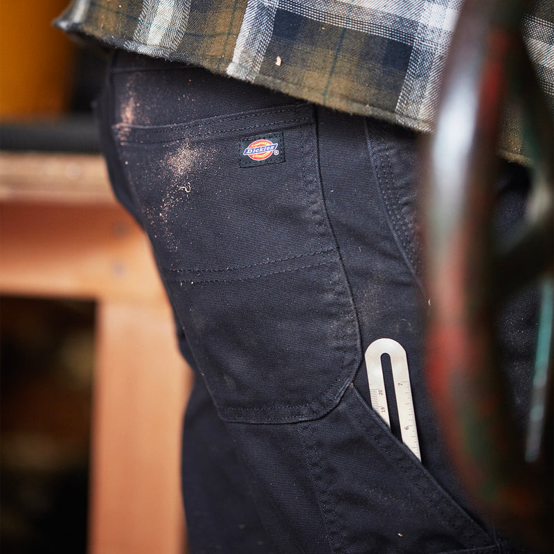 Men's black carpenter pants with side pocket and utility slot detail
