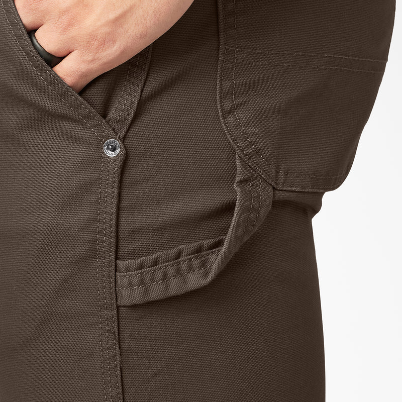 Close-up of dark brown carpenter pants: button fly and stitched front pocket.