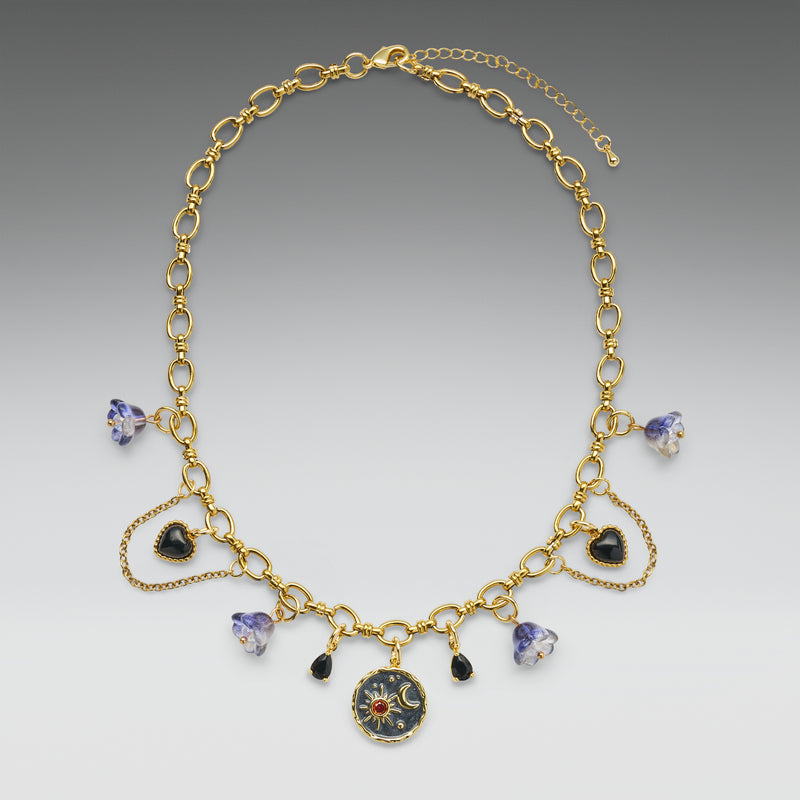 Gold necklace with heart and round pendants on a gray background