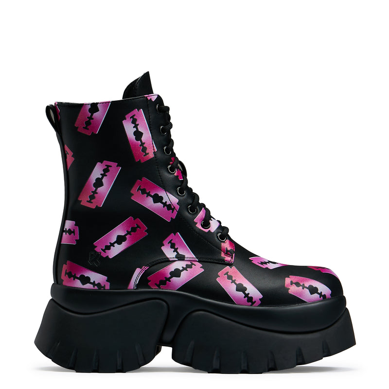 Black platform boots with a pattern of pink razorblade prints, featuring a lace-up front and a chunky sole.