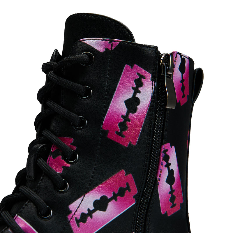 Black platform boots with a pattern of pink razorblade prints, featuring a lace-up front and a chunky sole - zipper detail