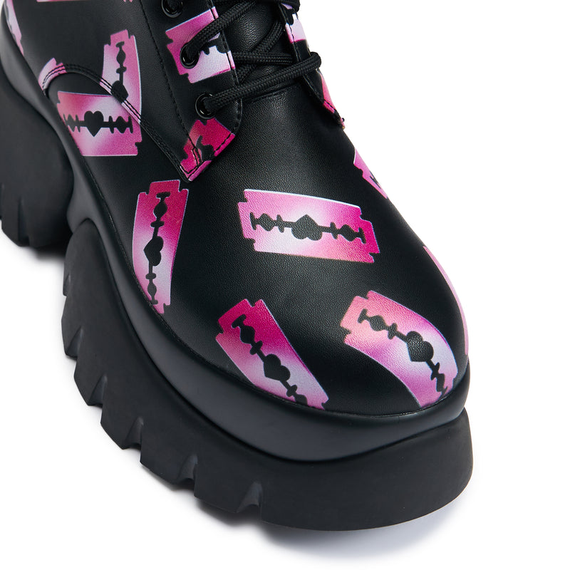 Black platform boots with a pattern of pink razorblade prints, featuring a lace-up front and a chunky sole - round toe detail