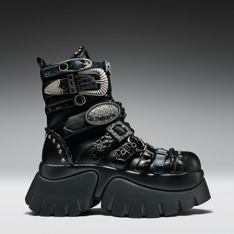 Black high-top boot with intricate designs and buckles on a gray background