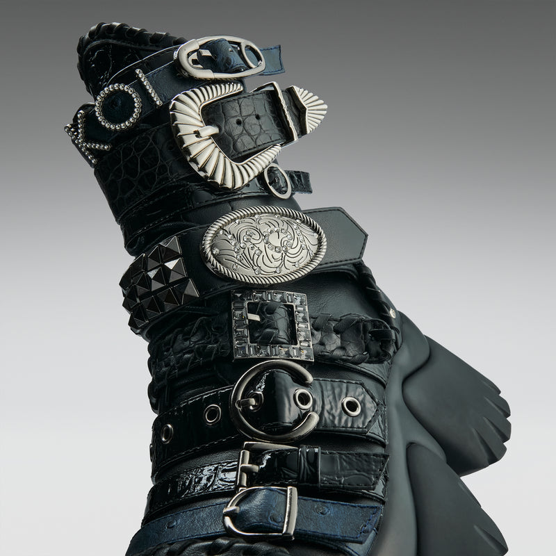 Black leather glove with silver buckles on a gray background