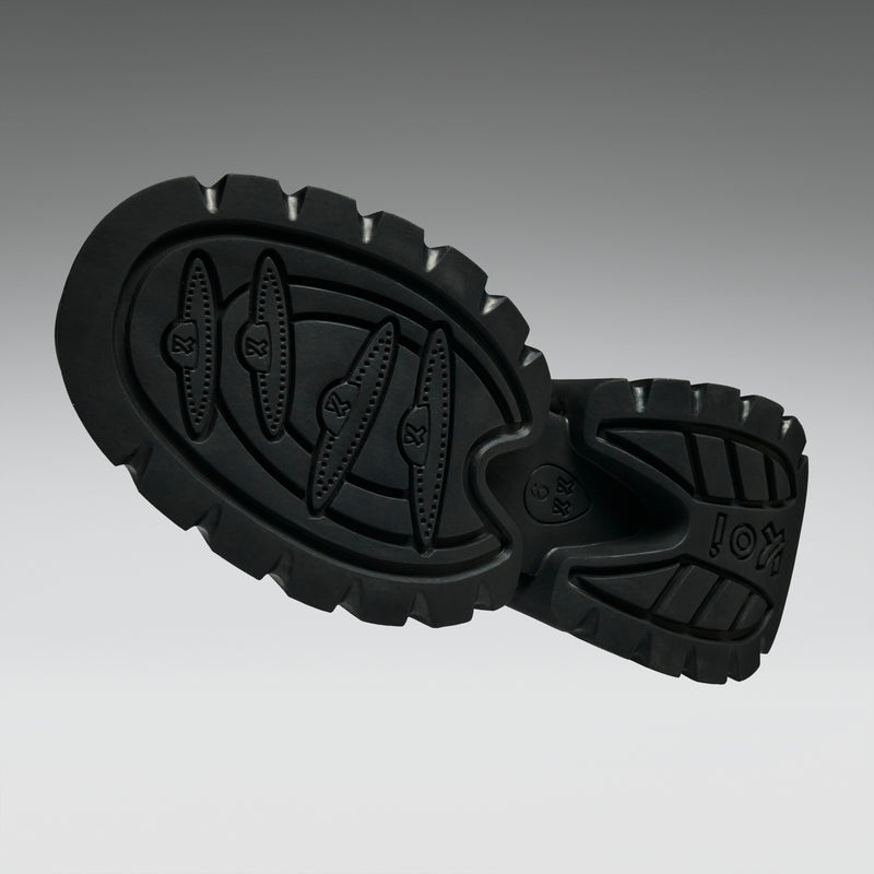 Black rubber sole with tread pattern on a gray background