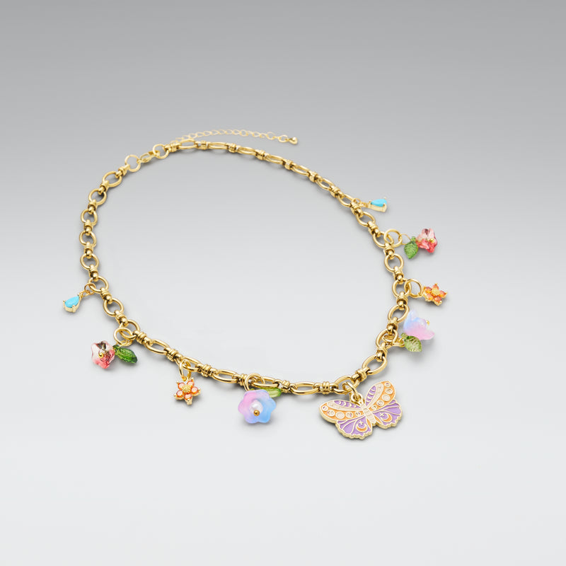 Gold anklet with colorful charms on a light gray background