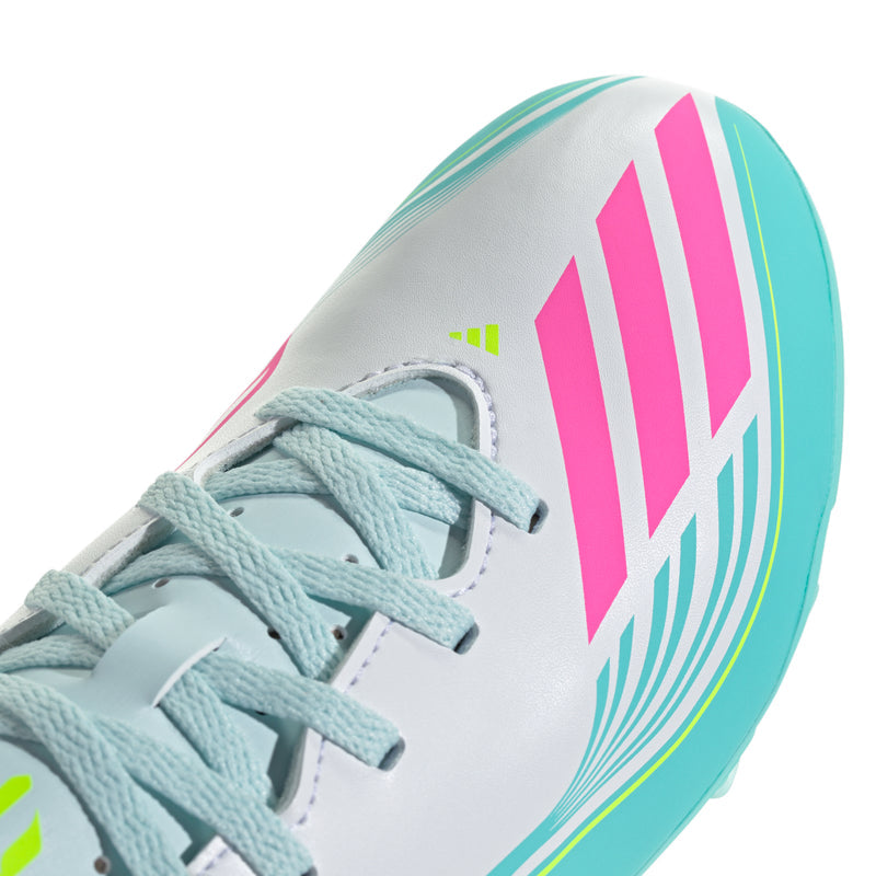 Youth soccer cleat closeup, white upper with aqua lining and pink/teal striped details