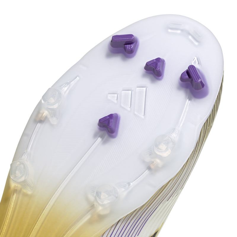Football cleat outsole close-up with purple studs and translucent sole, white upper base.