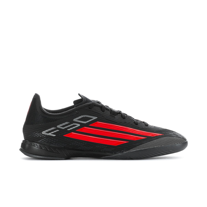 Black low-top soccer cleats with red stripe design and lace-up front.