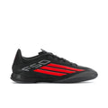 Black low-top soccer cleats with red stripe design and lace-up front.