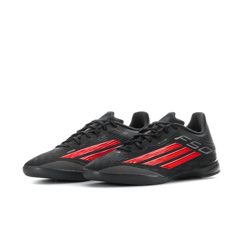Black soccer cleats with red side stripes and textured synthetic upper.