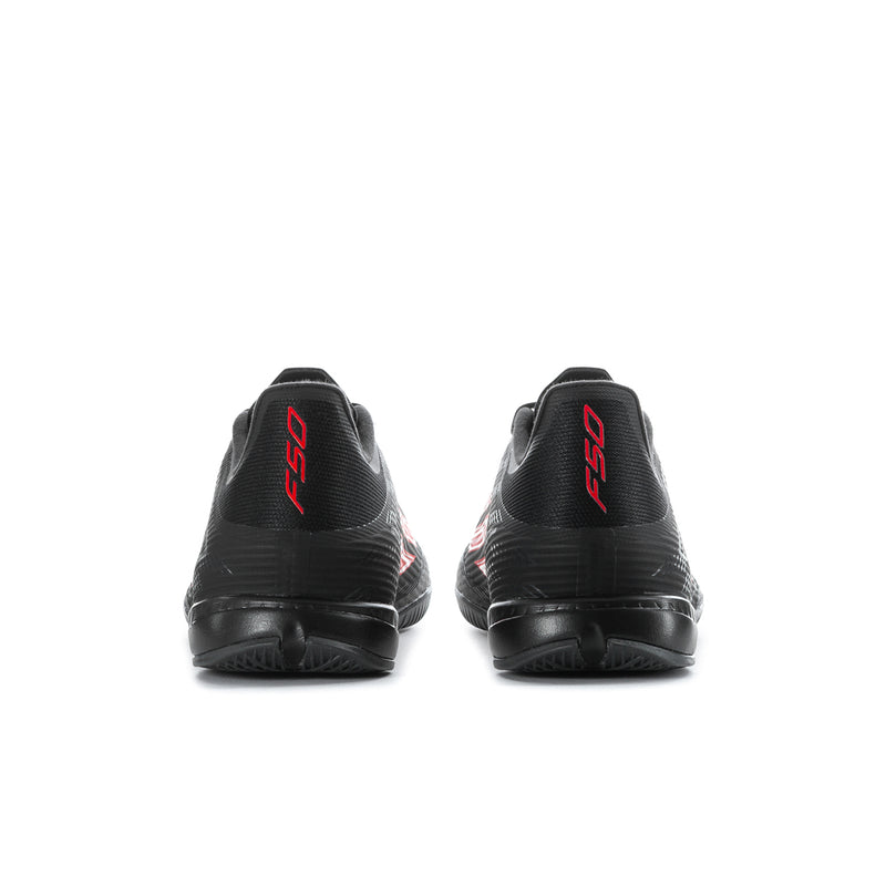 Black soccer cleats with red heel logos, back view.