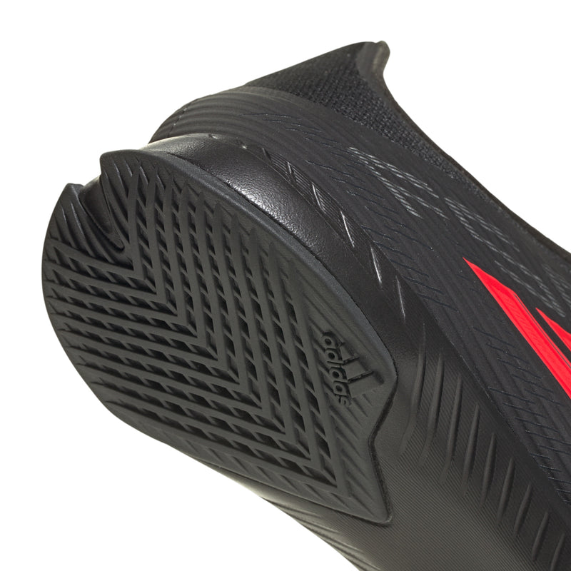 Black outsole close-up with adidas branding and molded grip tread.