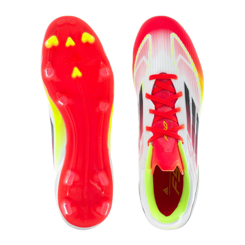 Pair of white/red/yellow soccer cleats showing tread with molded studs and red laces