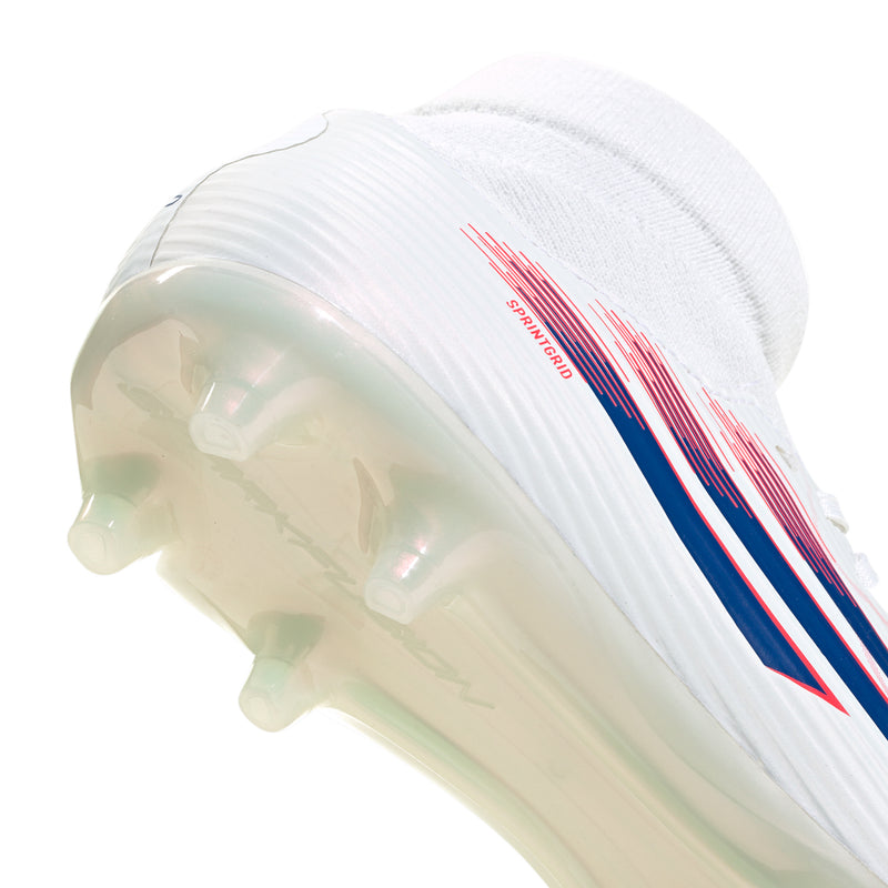 Women’s cleat sole close-up with blue studs and white molded traction, red accents