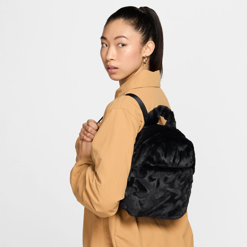 Black faux fur mini backpack with adjustable shoulder straps and rounded shape.