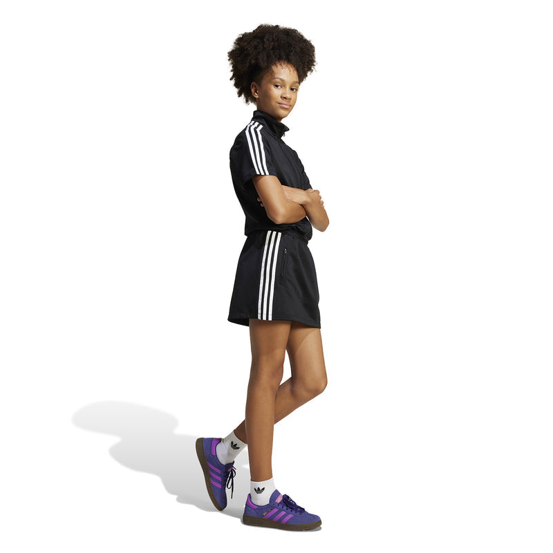 Youth black athletic dress with front zip and white side stripes, side view