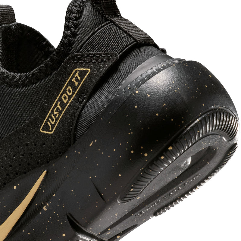 Kids' black sneaker close-up with gold swoosh, speckled finish, and grippy sole