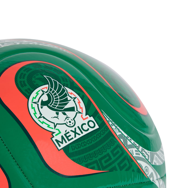 Green soccer ball close-up with Mexico crest on red-orange stripe and white patterned trim