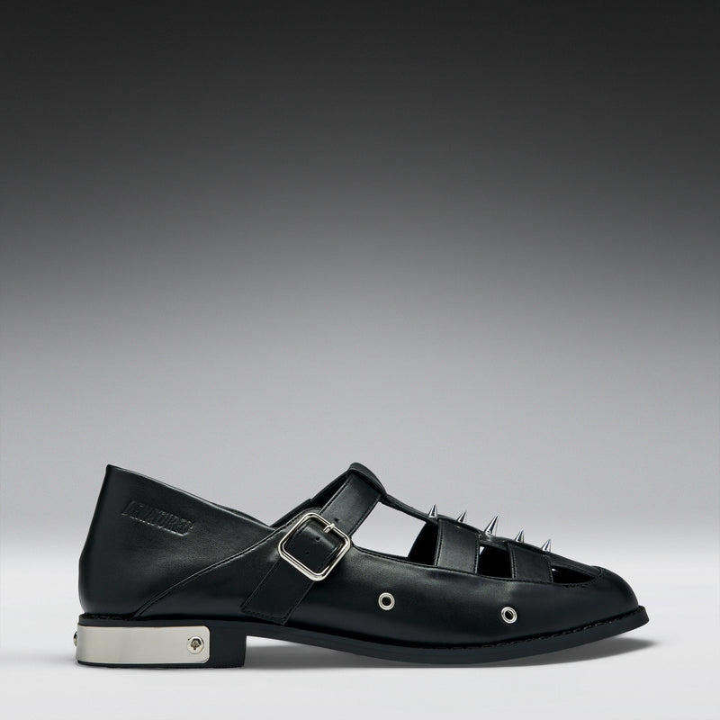 Black leather shoe with a buckle on a gray background