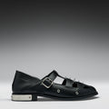 Black leather shoe with a buckle on a gray background