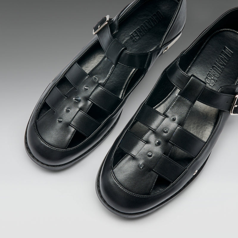 Pair of black leather sandals on a gray background