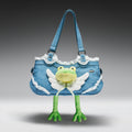 Denim handbag with a plush frog toy attached on a gray background