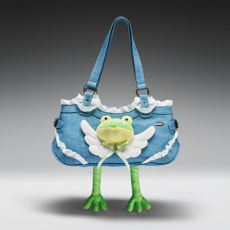 Denim handbag with a plush frog toy attached on a gray background