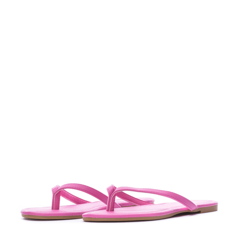 Women's fuchsia flip-flop sandals, angled view with thong strap and flat sole