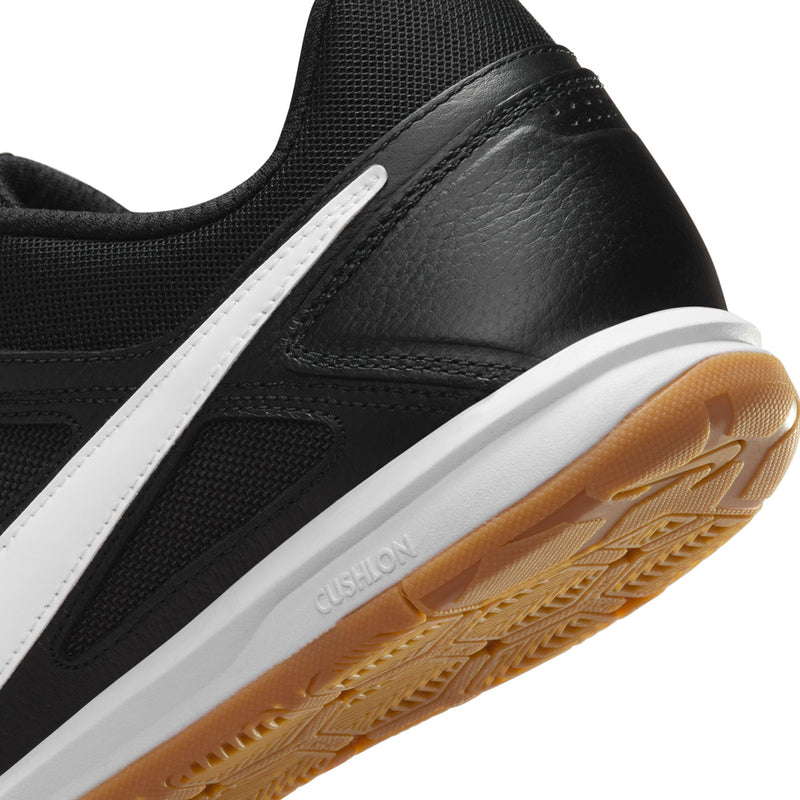 Black men's soccer shoe close-up of side panel, white stripe, and gum outsole