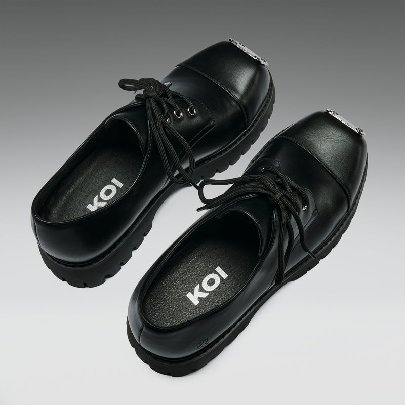 Black shoes with 'KOI' branding on a gradient background