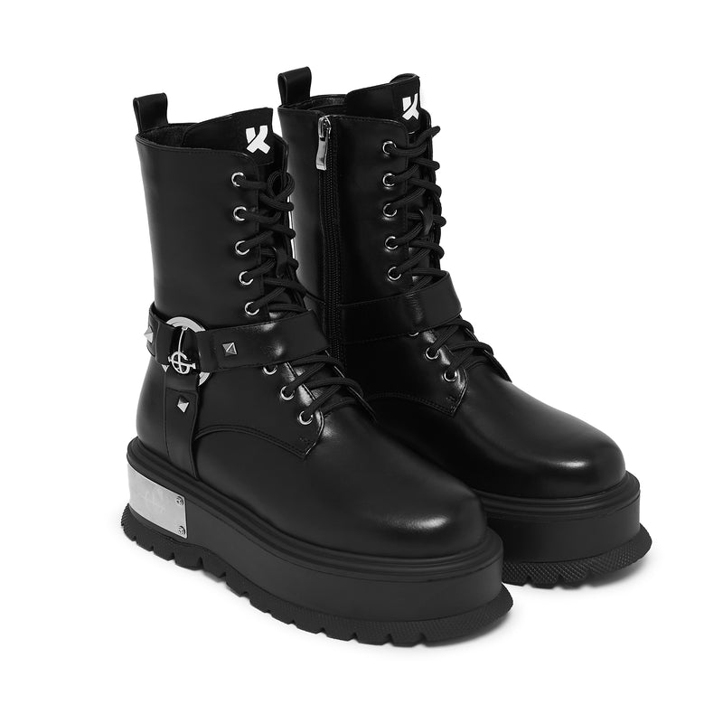 Black platform boots with silver accents on a white background