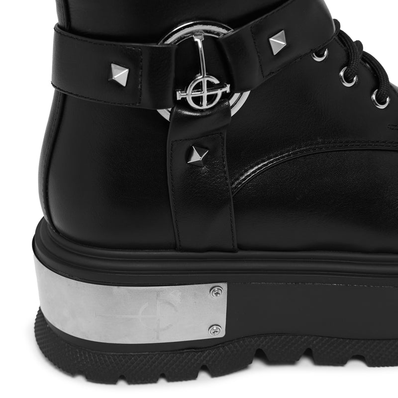 Black boot with silver buckle and studs on a white background