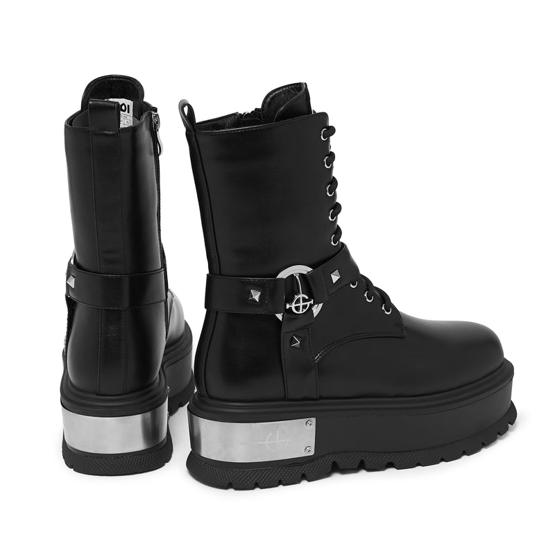 Black platform boots with silver accents on a white background