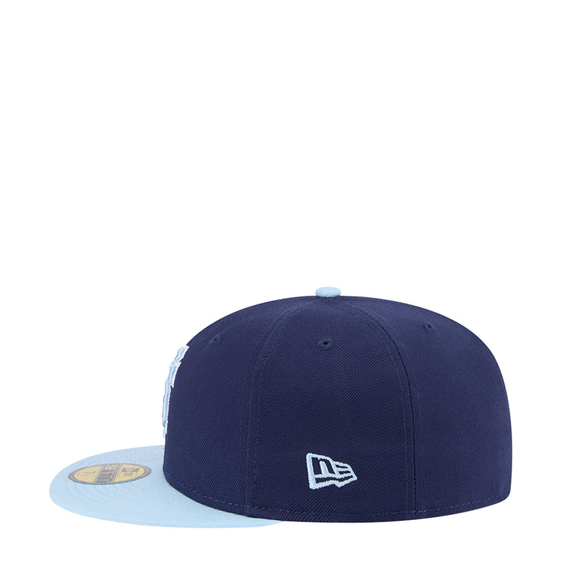 Two-tone baseball cap with dark navy crown, light blue brim, New Era logo patch