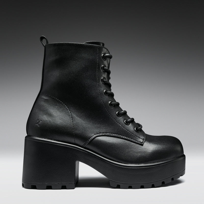 Black leather boot with a chunky sole on a gradient background