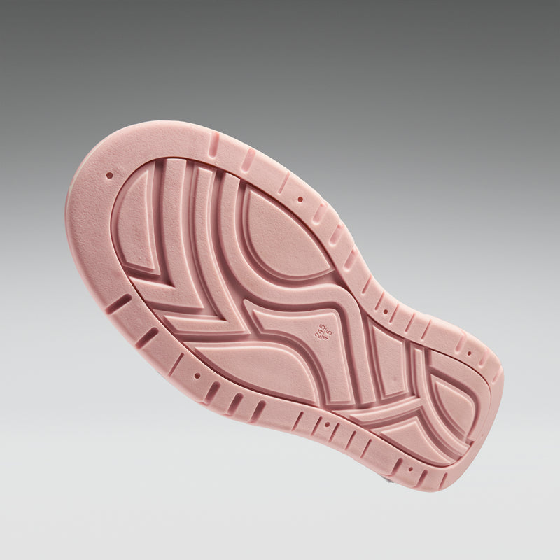 Pink shoe sole with tread pattern on a gray background