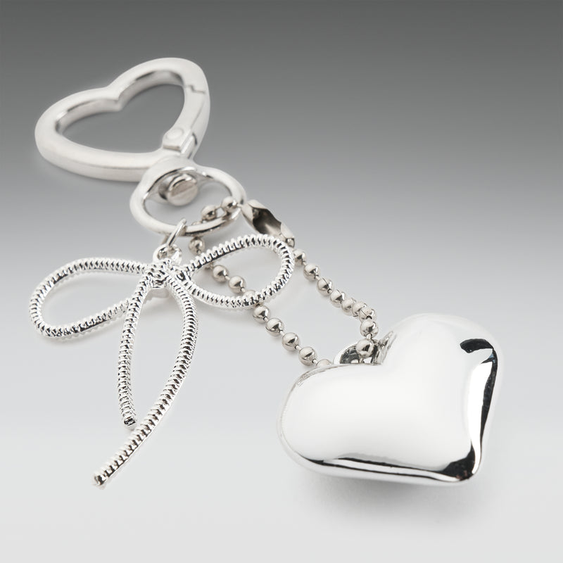 Silver heart-shaped keychain on a gray background