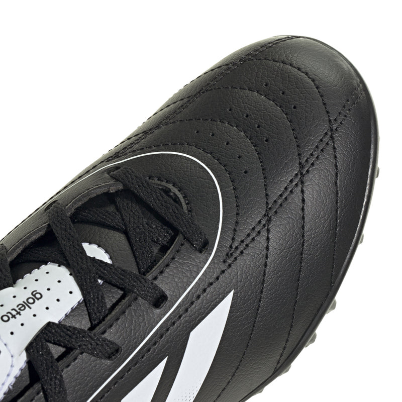 Youth black leather-look turf soccer cleat close-up of laces and side stripe