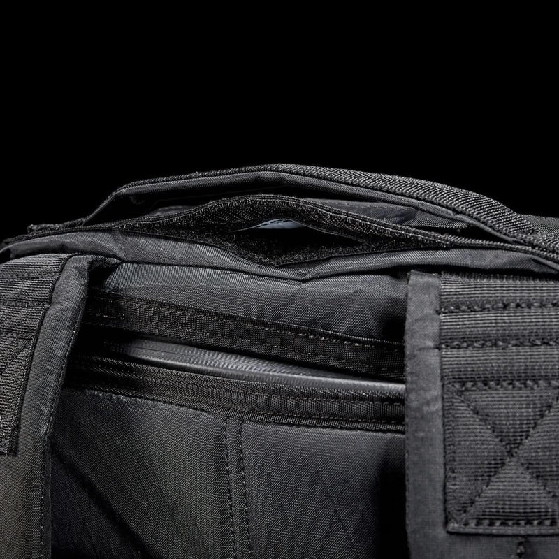 GORUCK black ruck backpack top handle and zipper detail against black background