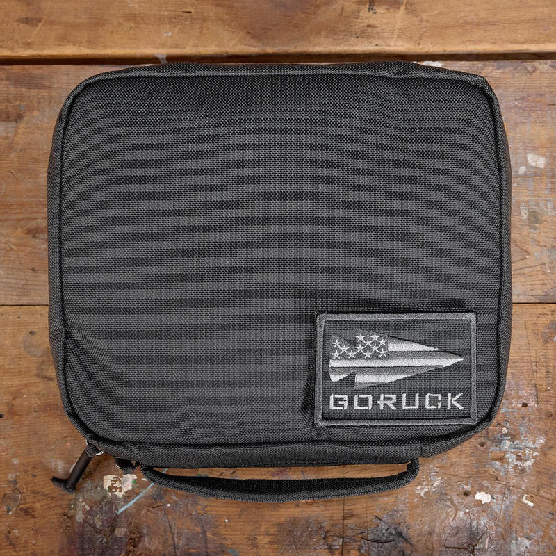 GORUCK padded field pocket in Armor Grey, displayed on wooden surface with GORUCK logo patch