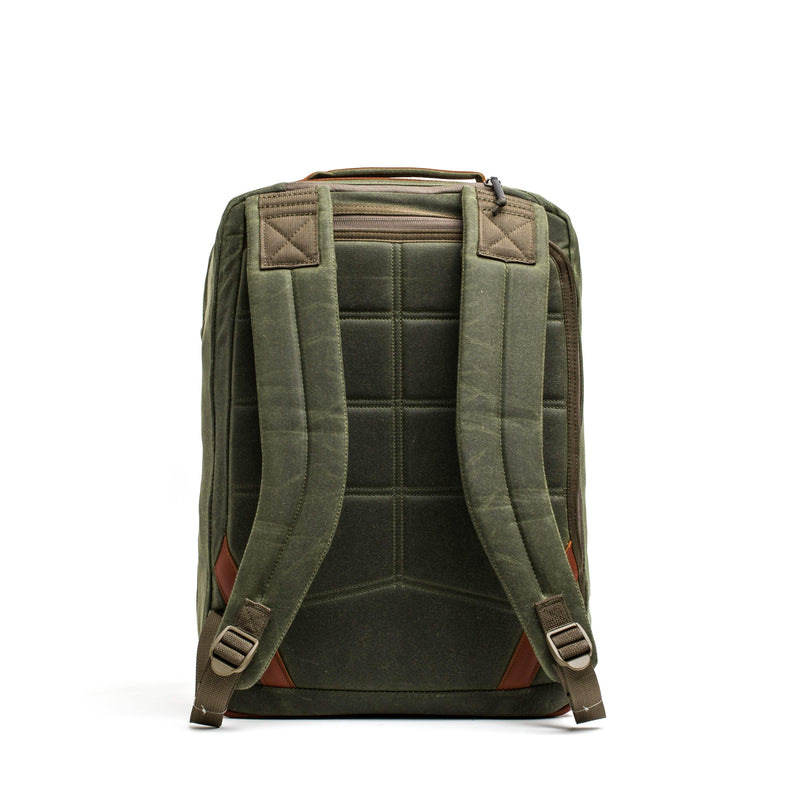 GORUCK olive waxed canvas backpack with brown leather accents and padded straps, rear view