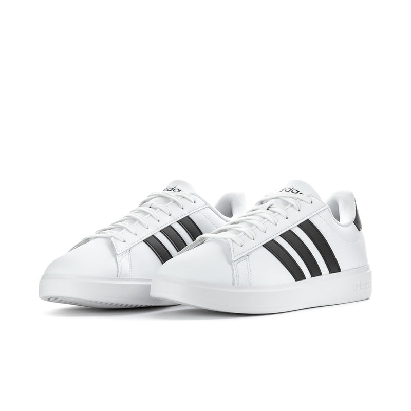Pair of men's white low-top sneakers with black three-bar stripes and lace-up