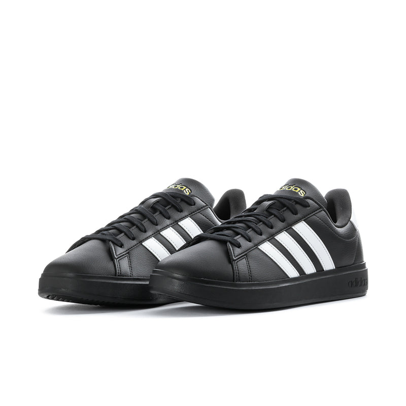 Pair of men's black low-top sneakers with white triple stripes and black laces